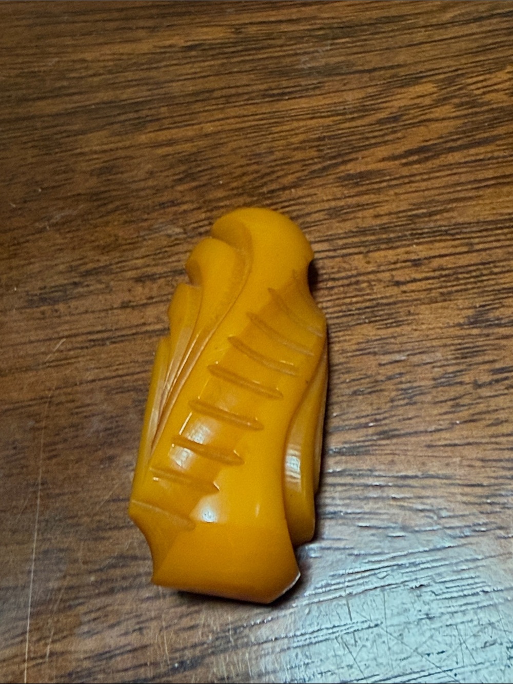 vintage butterscotch Bakelite dress clip, featuring intricate carved leaf design